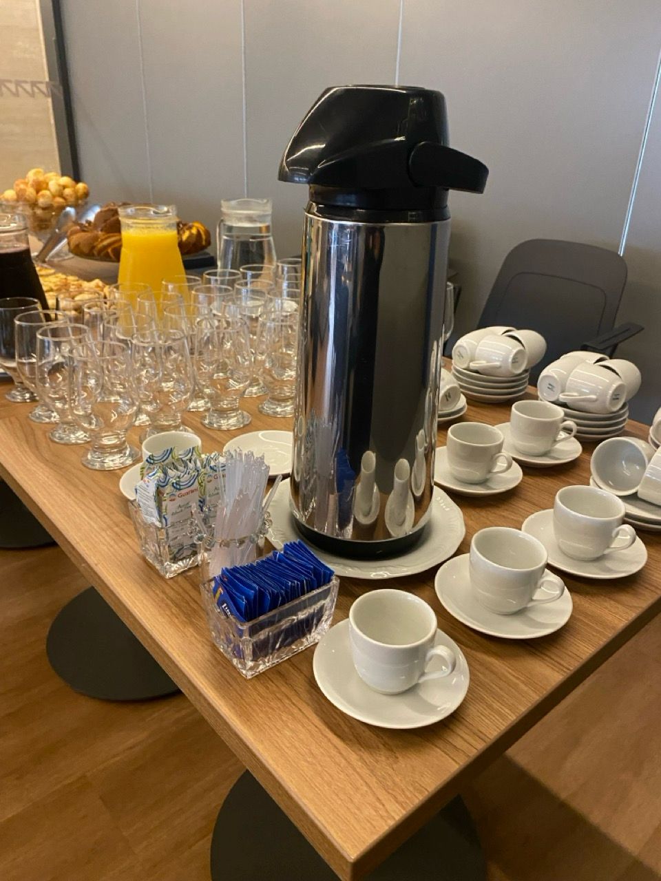 Mesa de coffee break com mini quiches, pães e frutas