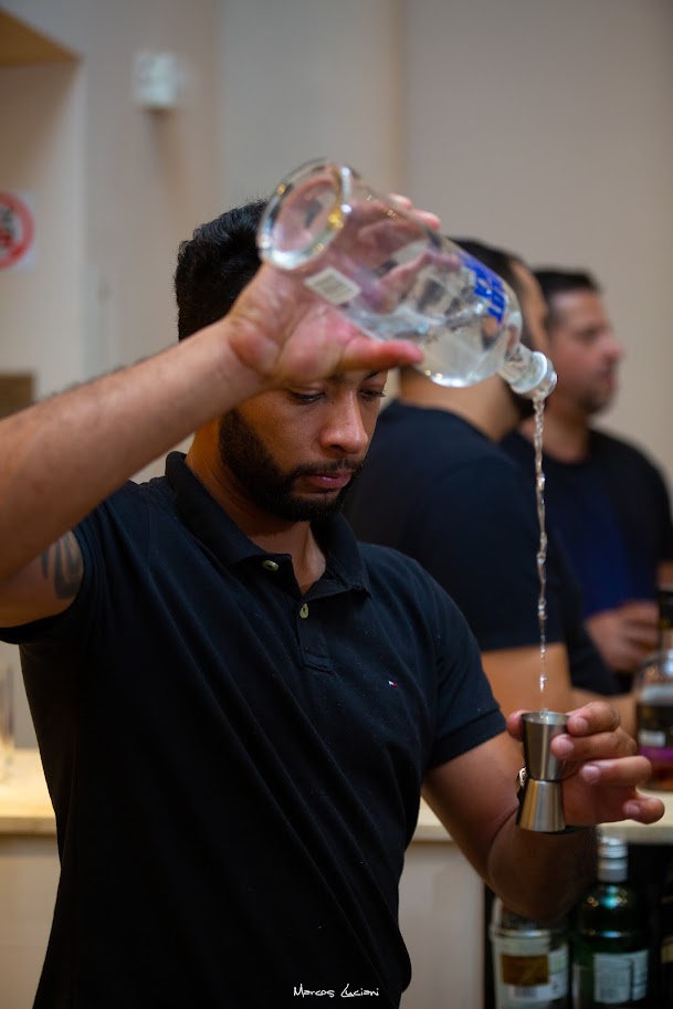 Bartender preparando drink no balcão